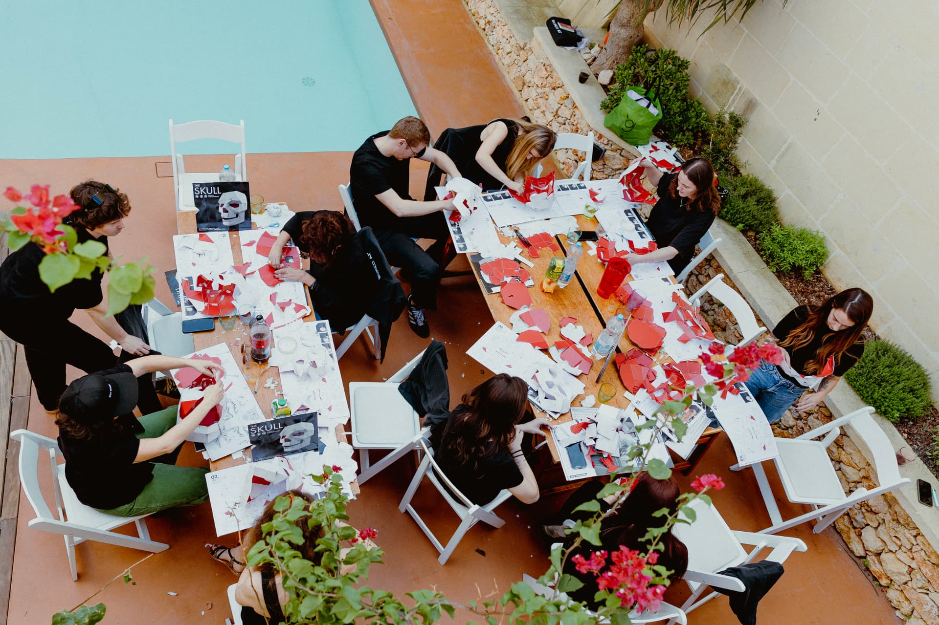 Team working around a poolside table in Gozo
