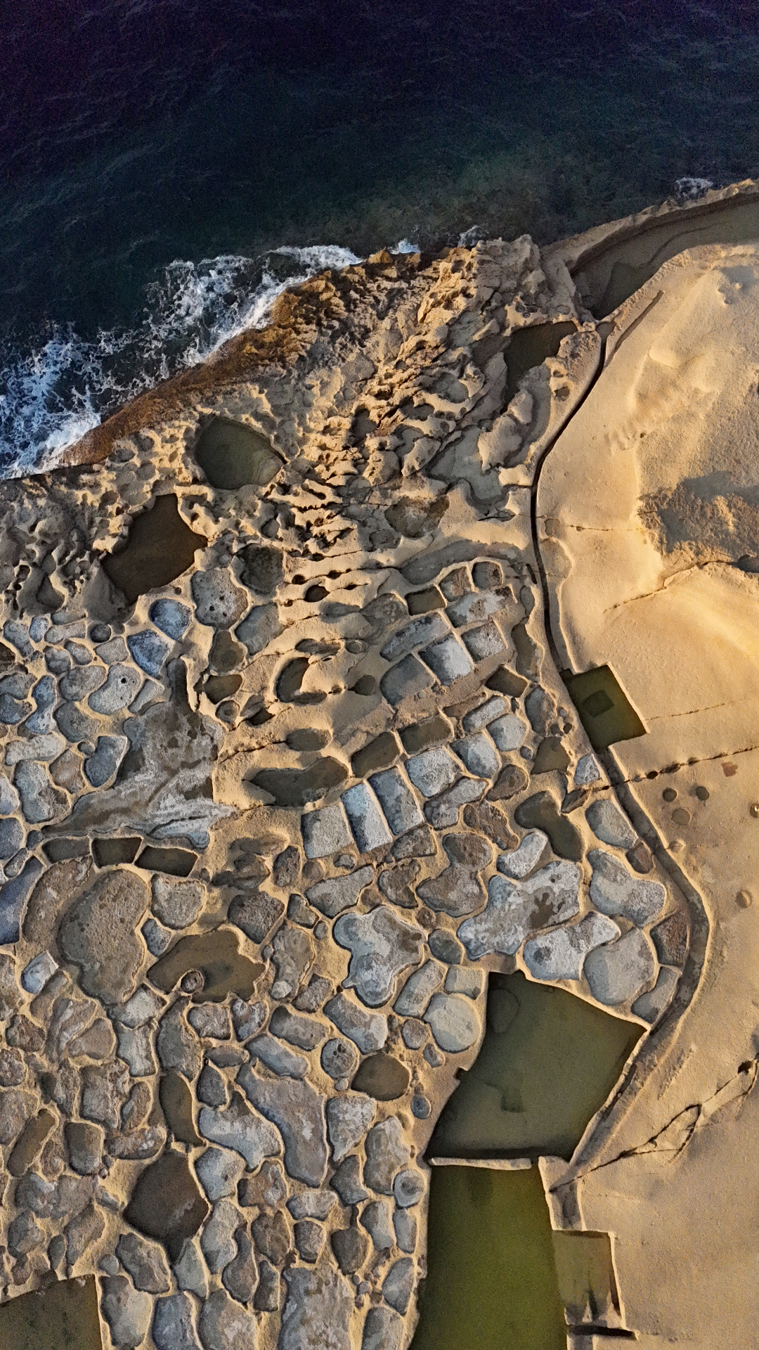 Aerial view of the Gozo salt pans meeting the sea